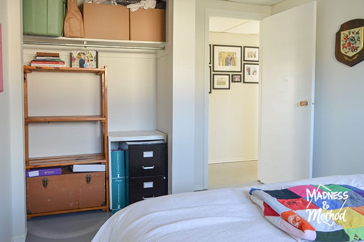 bedroom closet with wood shelves and black filing cabinet