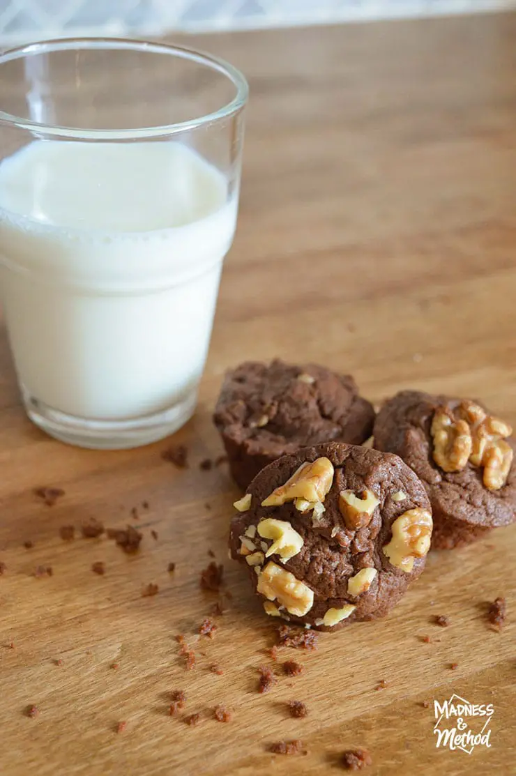 brownies with glass of milk on wood counter with crumbs