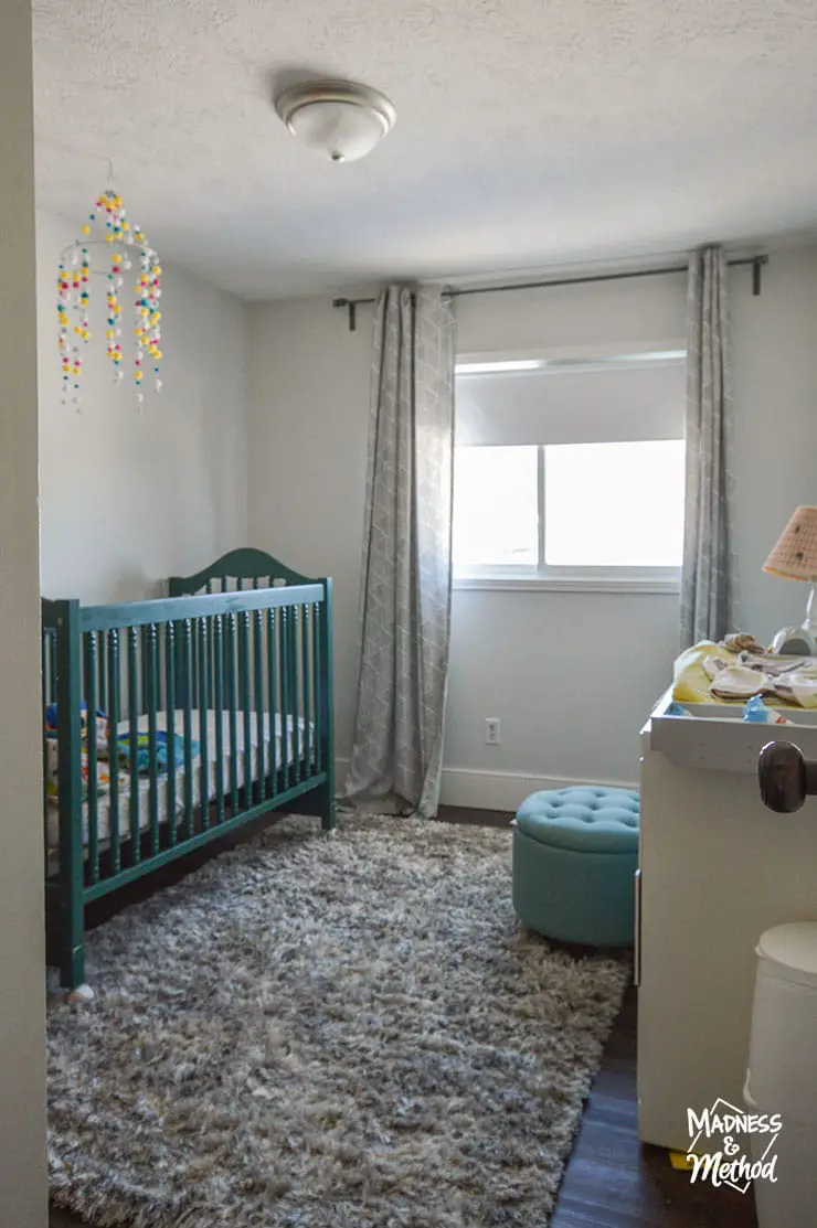 nursery with green crib turquoise ottoman and gray shag rug