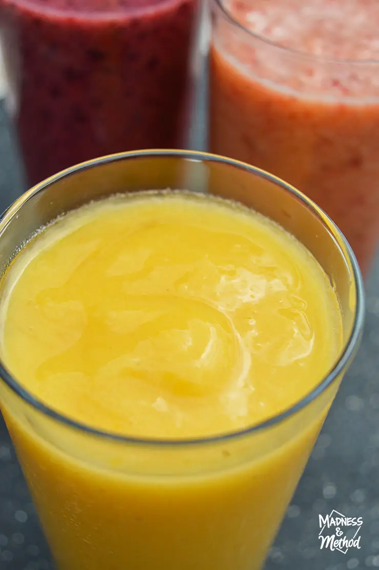 closeup of yellow smoothie glass with others behind