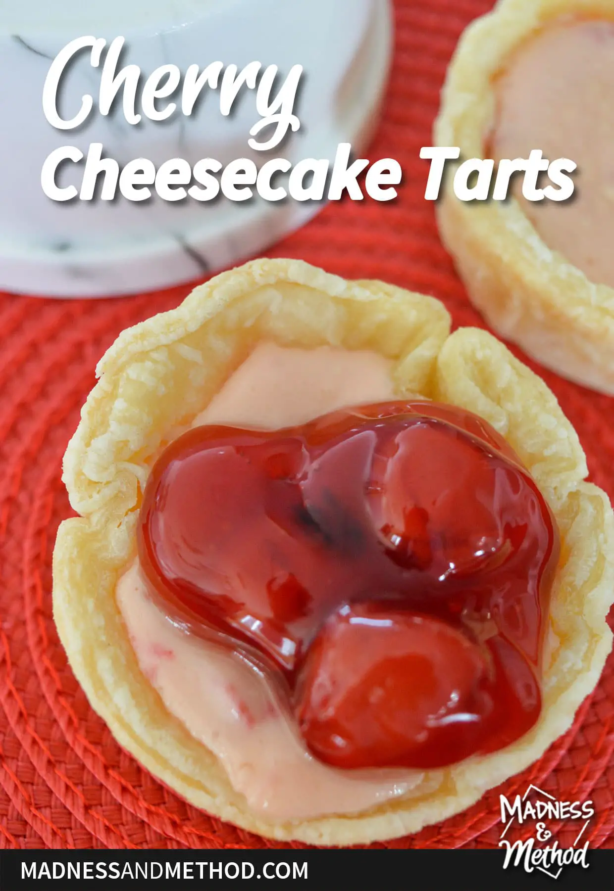 cherry cheesecake tarts text overlay on mini cheesecake with cherry filling