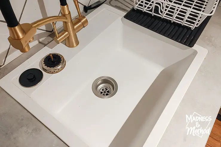 white kitchen sink with gold faucet