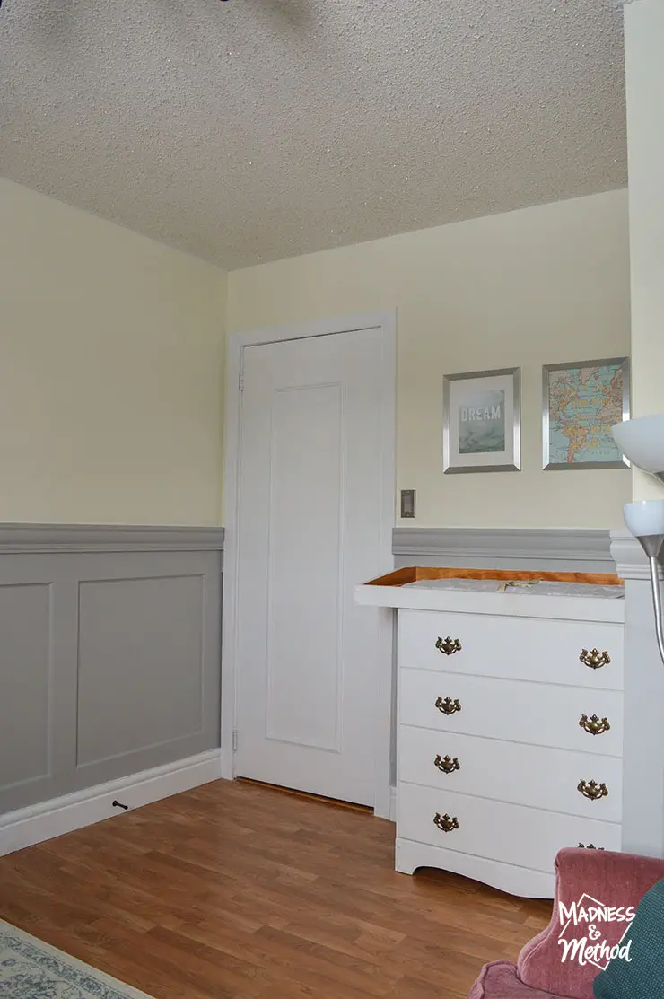 light yellow walls and gray wainscoting near white door