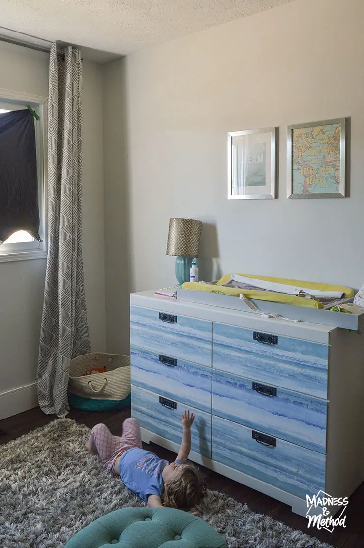 blue and white dresser with toddler on shag rug