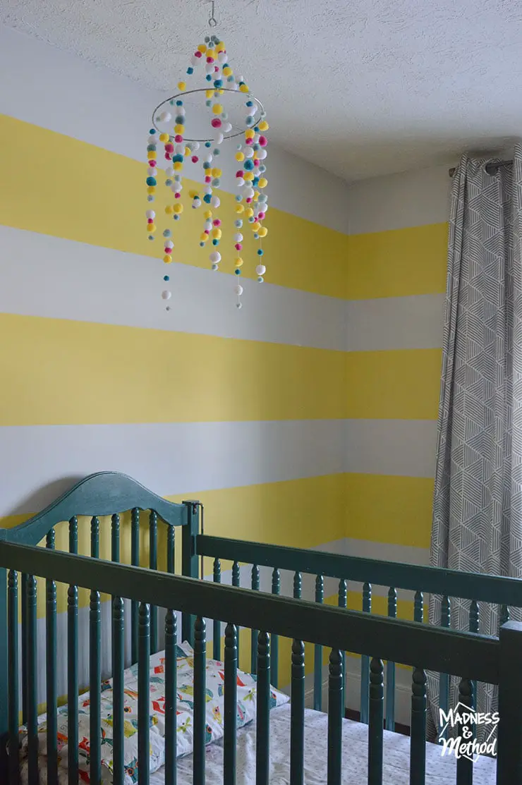 yellow white striped nursery with green crib
