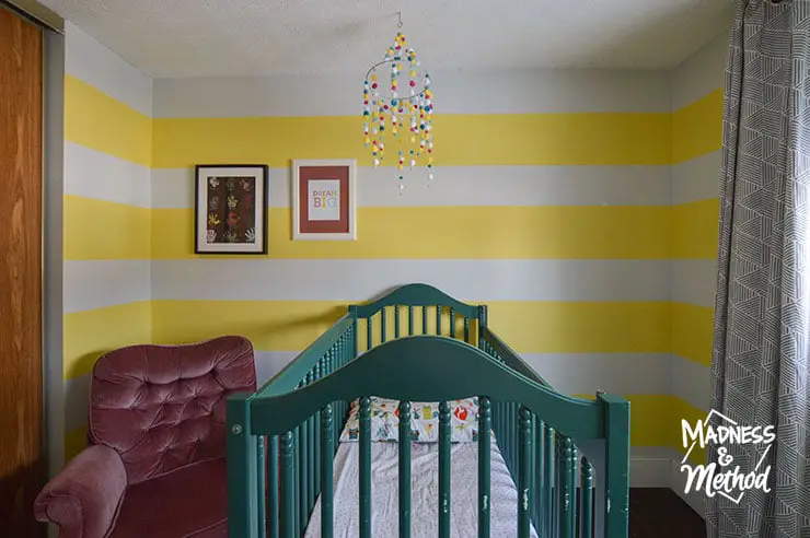 striped nursery with white and yellow walls