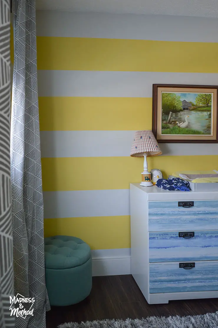 yellow white striped walls with white and blue dresser