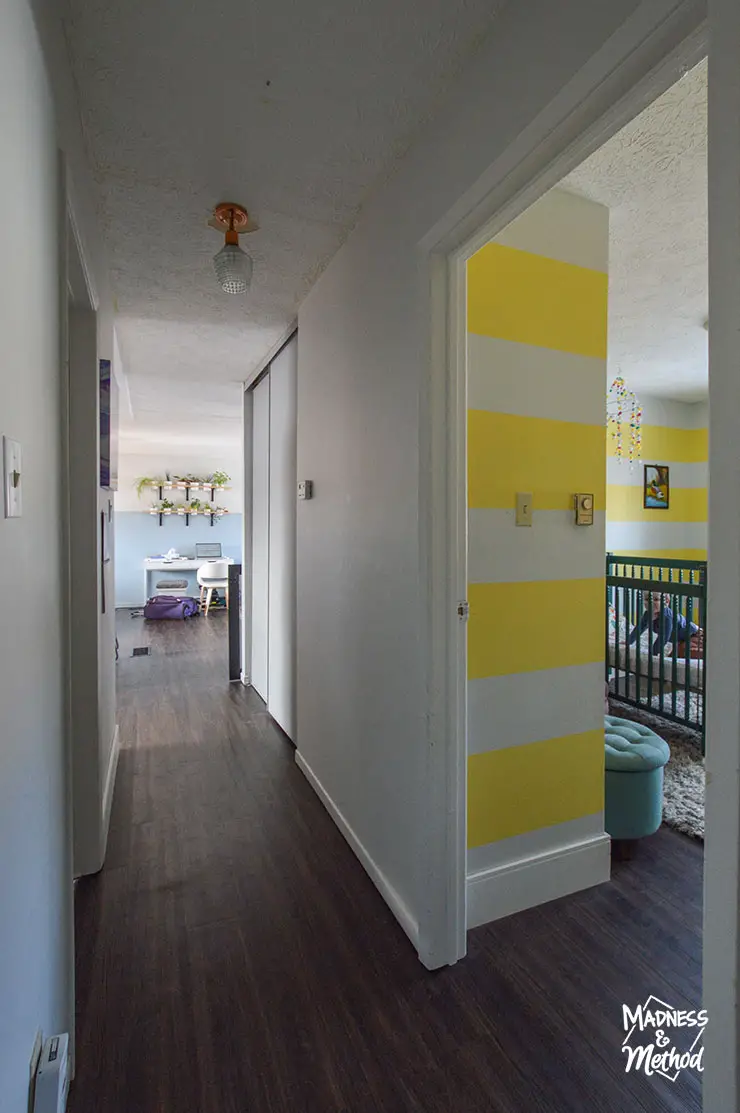 white hallway with peek into bright bedrooms
