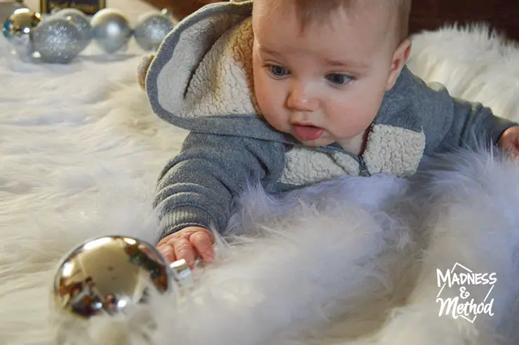 baby reaching for silver ornament