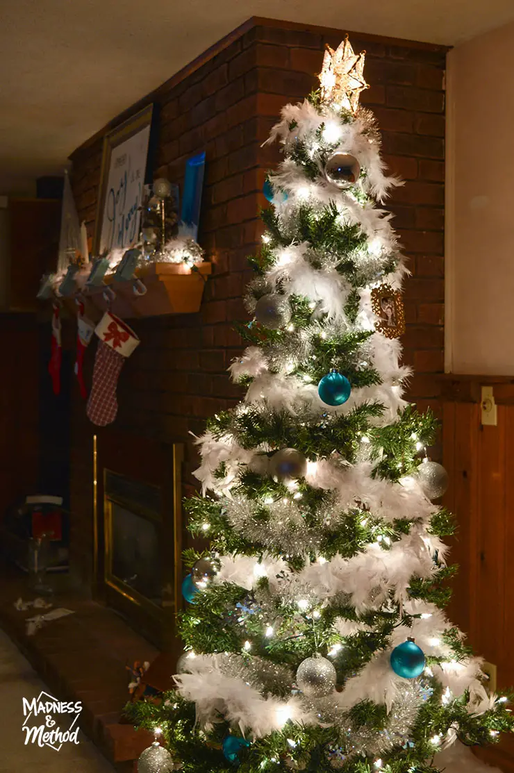 christmas tree in basement next to brick fireplace