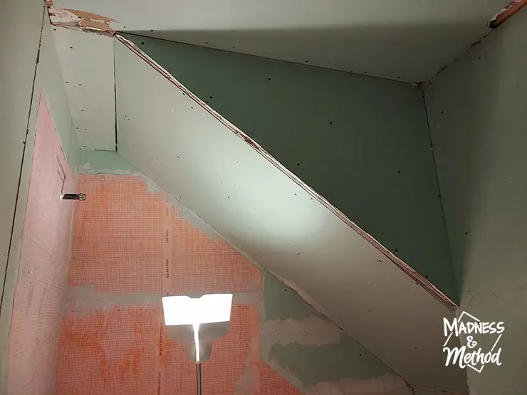 angled shower ceiling under stairs