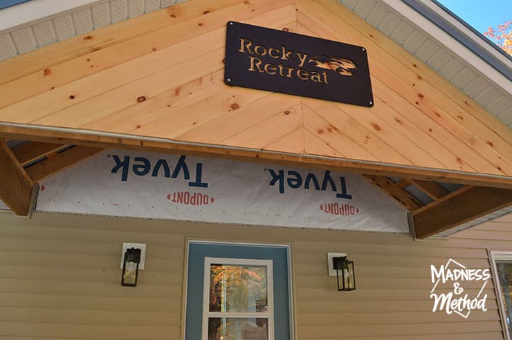 unfinished cottage porch with sign