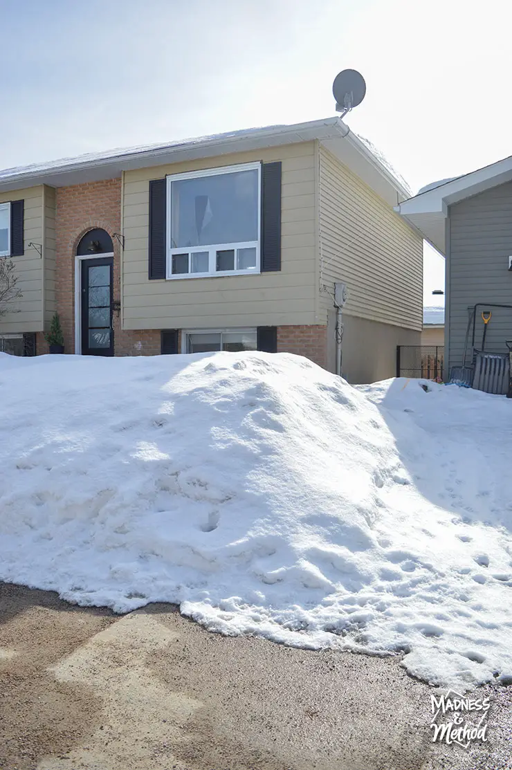 snow pile in front of raised ranch house