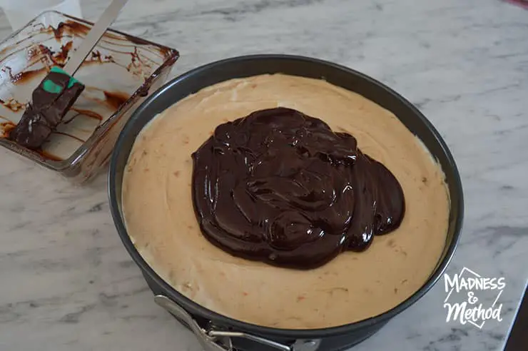 spreading chocolate on cheesecake top
