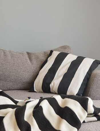 black white stripe pillow and blanket on gray couch