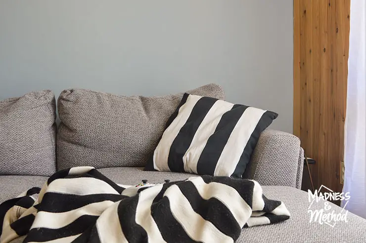 black white stripe pillow and blanket on gray couch