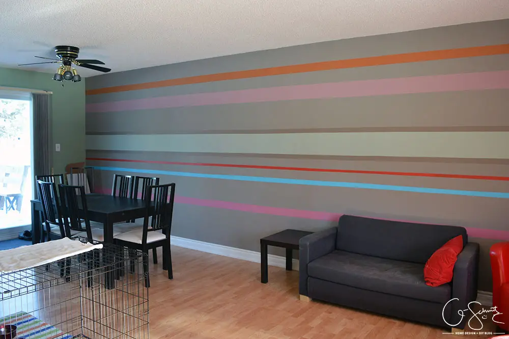 Our striped accent wall helps bring all the crazy and wild colours we used throughout the house into one cohesive location!