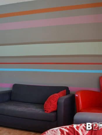 Our striped accent wall helps bring all the crazy and wild colours we used throughout the house into one cohesive location!