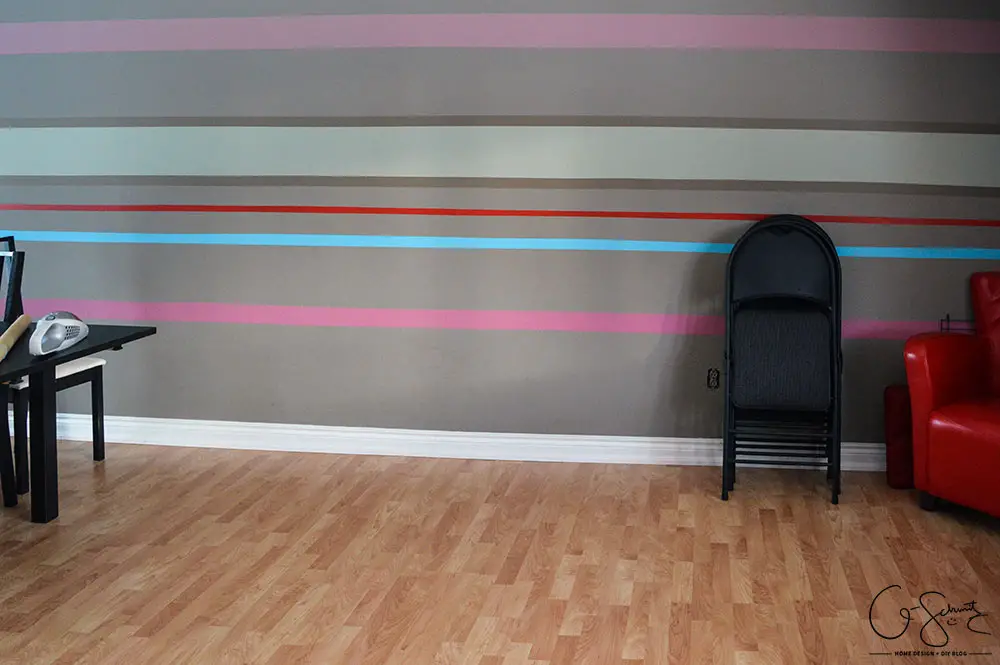Our striped accent wall helps bring all the crazy and wild colours we used throughout the house into one cohesive location!