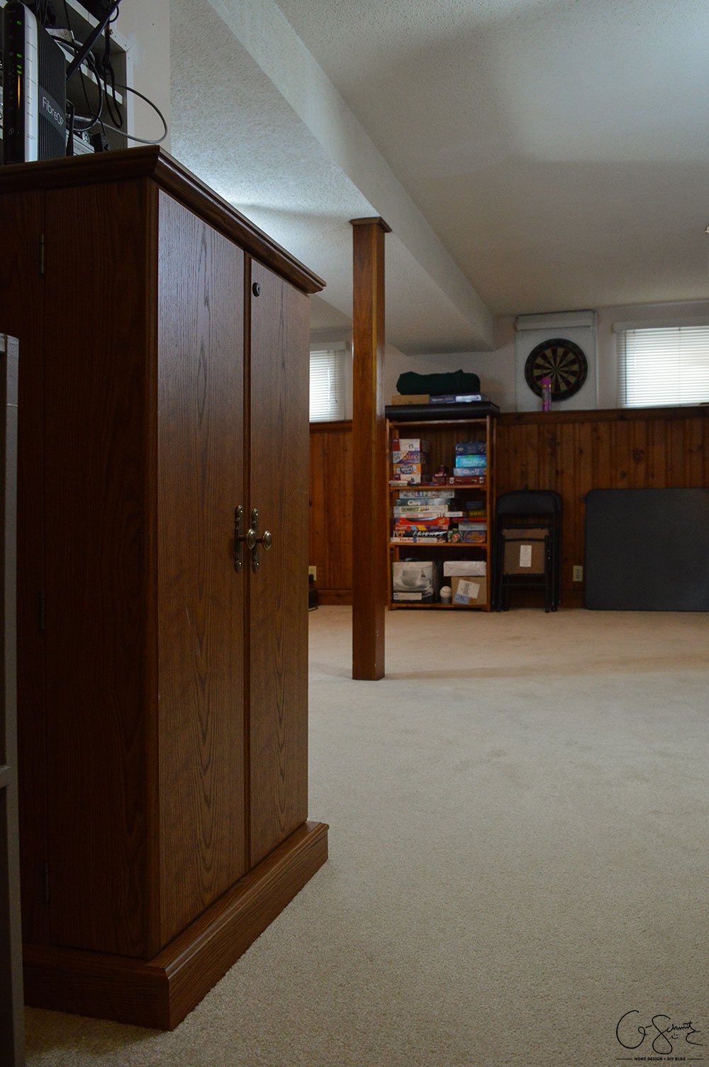 My basement is definitely "country". Think plaid and dark wood paneling, and that pretty much describes this space. You know what style I am not? Country! But, let's look at pictures of the basement anyways, along with my lovely little comments of issues I would change...