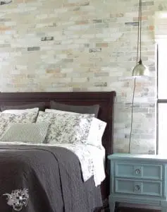 bedroom with light brick accent wall