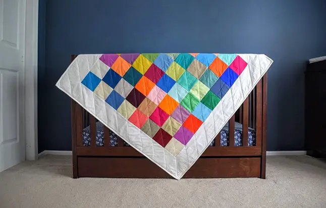 If you're someone like me that's held on to some old t-shirts and wanted to put them to good use, then you can certainly use this idea! Check out how I was able to repurpose years’ worth of (mostly) free clothing to create a custom t-shirt baby quilt.