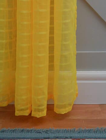 bright yellow curtain on gray wall and white trim