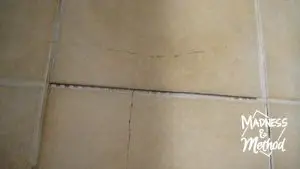 closeup of cracked tile with grout removed