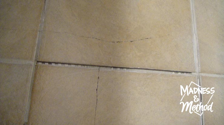 closeup of cracked tile with grout removed