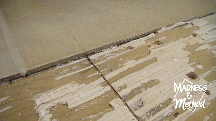 looking at gap in subfloor under cracked tile