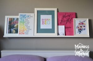 Photo ledge above a bed with pictures