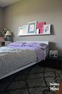 Guest bedroom setup with photo ledge behind bed