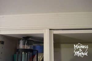 caulking seams along trim above cabinets