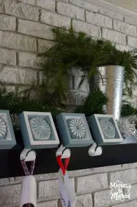 simple silver and green holiday mantel with greenery
