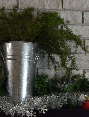 bucket with greenery on holiday mantel