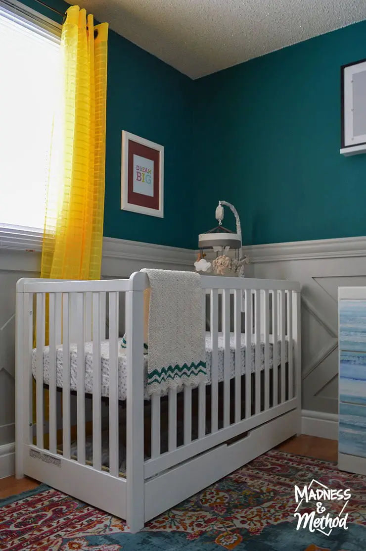 dark teal walls and white crib