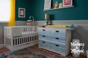 dark teal nursery with white furniture
