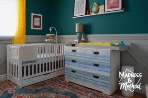 dark teal nursery with white furniture