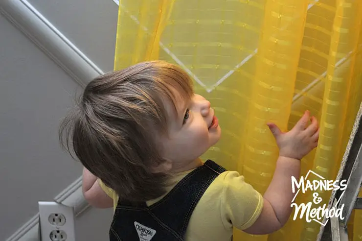 toddler playing with curtains