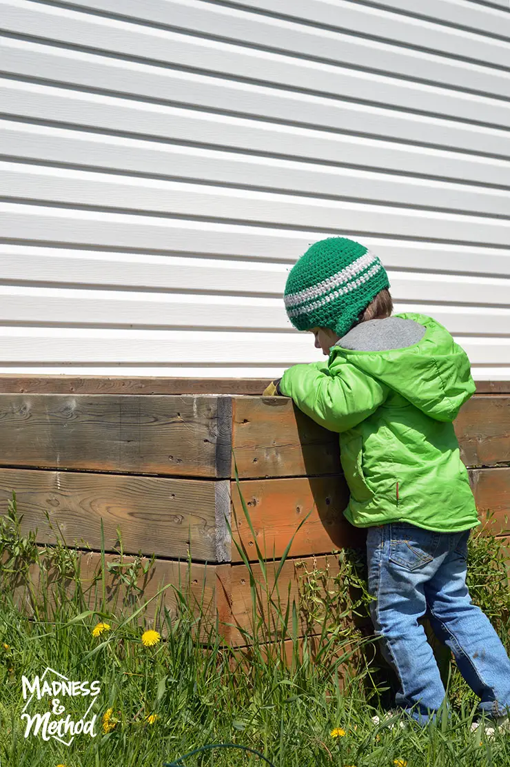 toddler next to raised garden