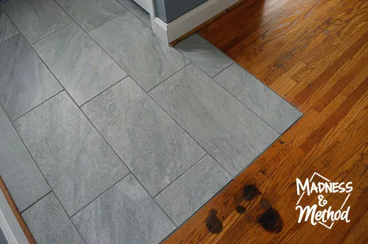 grey tiles next to wood floors