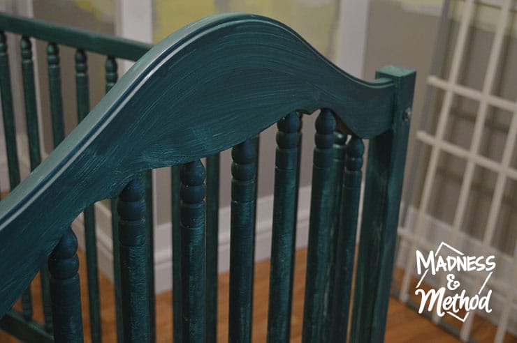 first coat of dark teal paint on crib