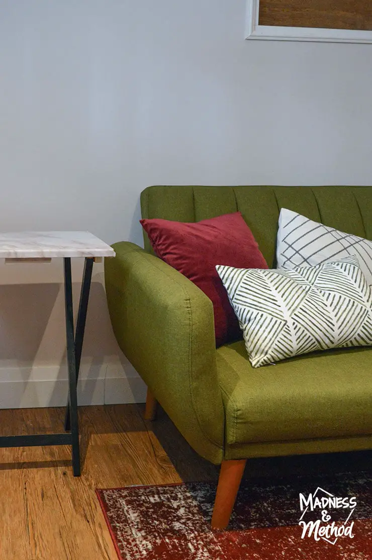 green sofa with red and white pillows