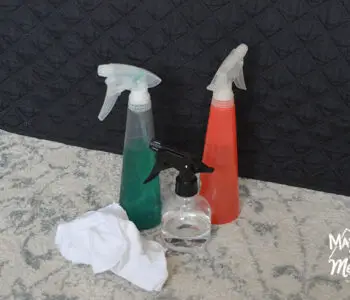 three spray bottles near rag on rug