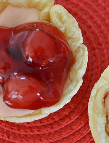 muffin sized cherry cheesecake tart on red background