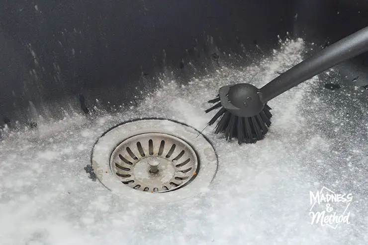 black kitchen sink with black scrubber and white powder