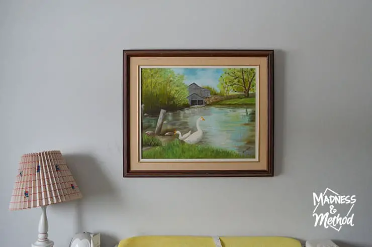 water landscape on white wall next to lamp
