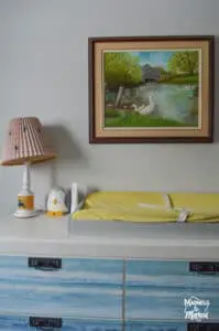 yellow change table pad near painting and lamp