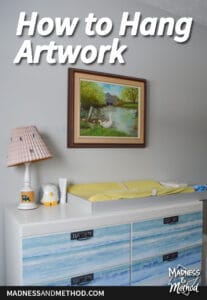 how to hang artwork text overlay with blue and white dresser