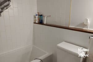 white subway tile tub surround with wood ledge